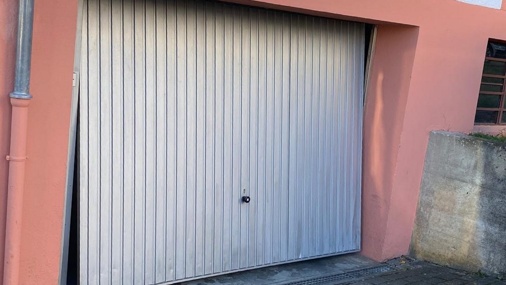 Altes Schwingtor an einer Garage vor dem Austausch